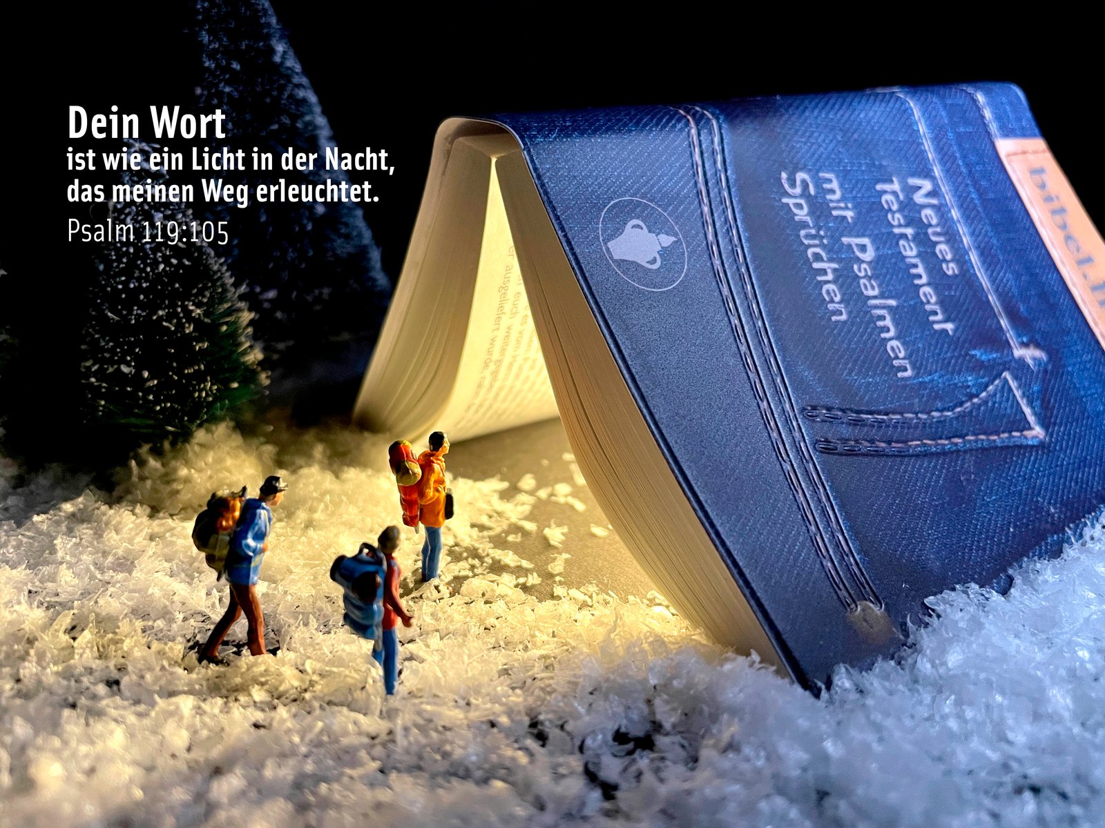 Miniatur-Wanderer im Schnee vor einem aufgestellten Neuen Testament, aus dem warmes Licht fällt, dazu Psalm 119,105: „Dein Wort ist wie ein Licht in der Nacht“