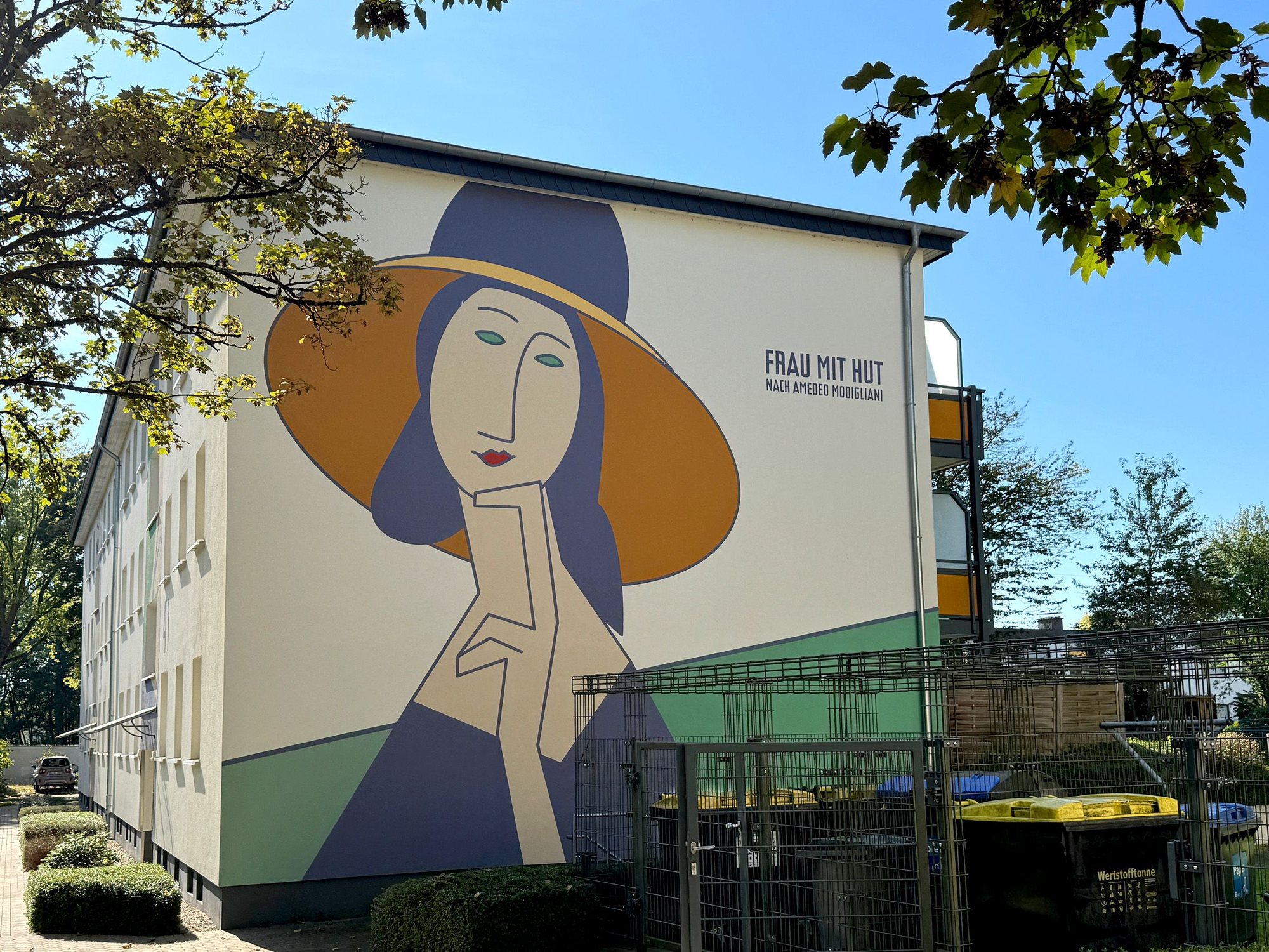 Giebelwand mit dem Fassadenbild „Frau mit Hut“ nach Amedeo Modigliani im grünen Innenhof