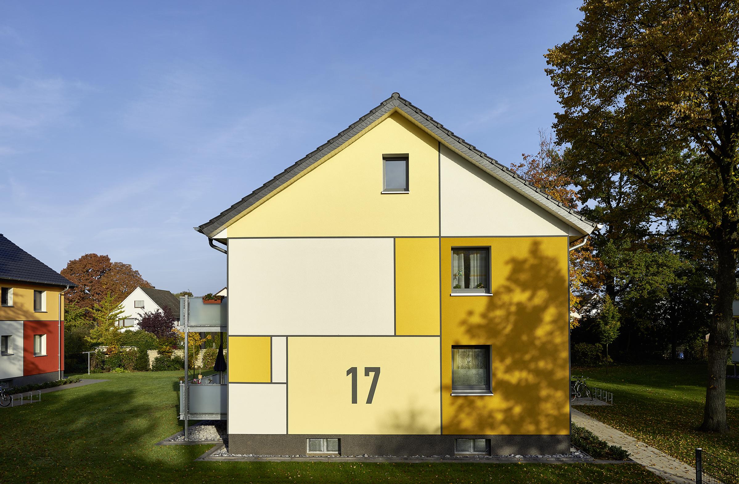 Giebel eines Hauses mit Farbflächen in Gelbtönen und der Hausnummer 17
