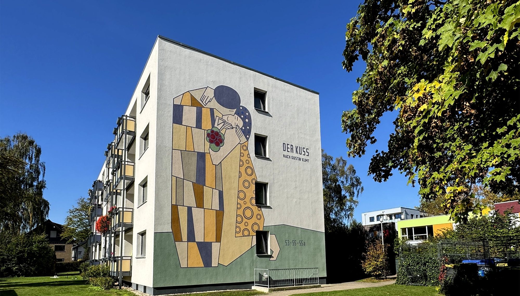Wohnhaus im Rabenhof mit dem Fassadenbild „Der Kuss“ nach Gustav Klimt an der Giebelwand, unter blauem Himmel
